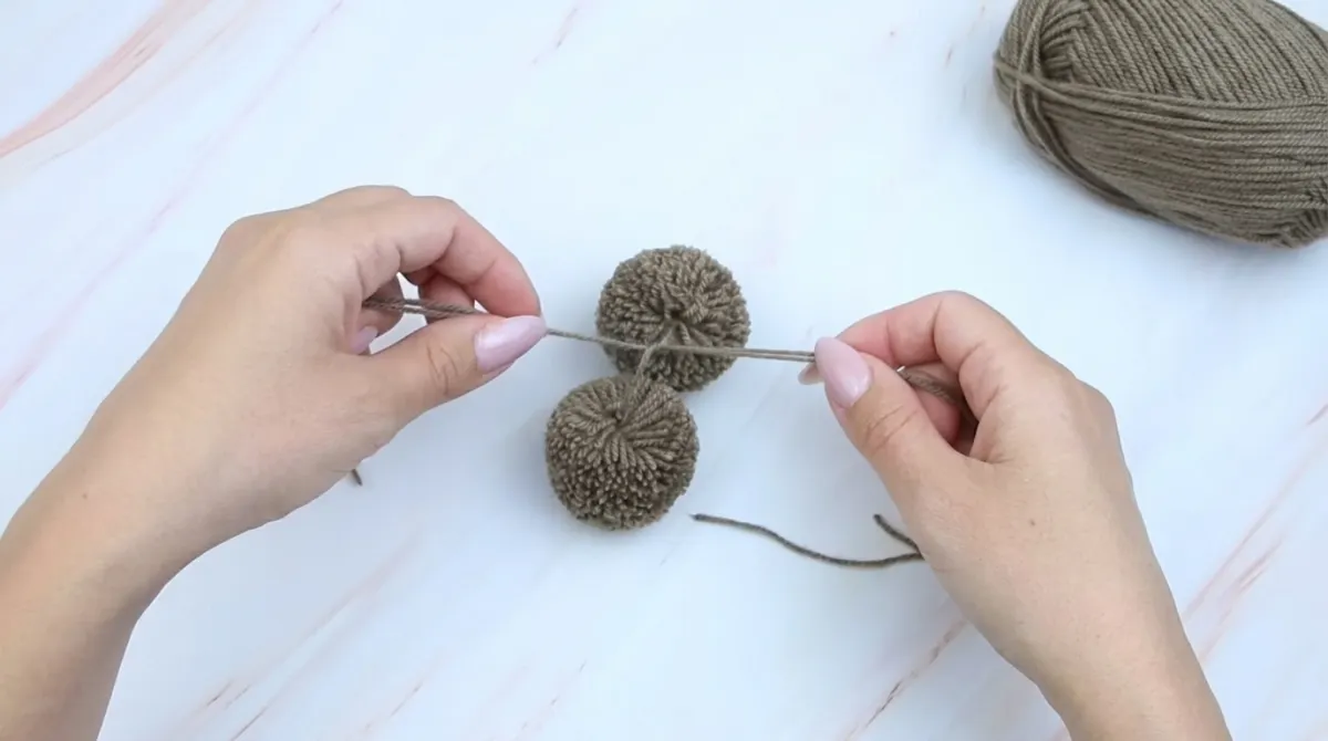 Step 10: Tie the Two Pom-Poms Together
