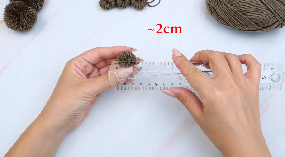 Step 16: Check the Size of the Small Pom-Poms
