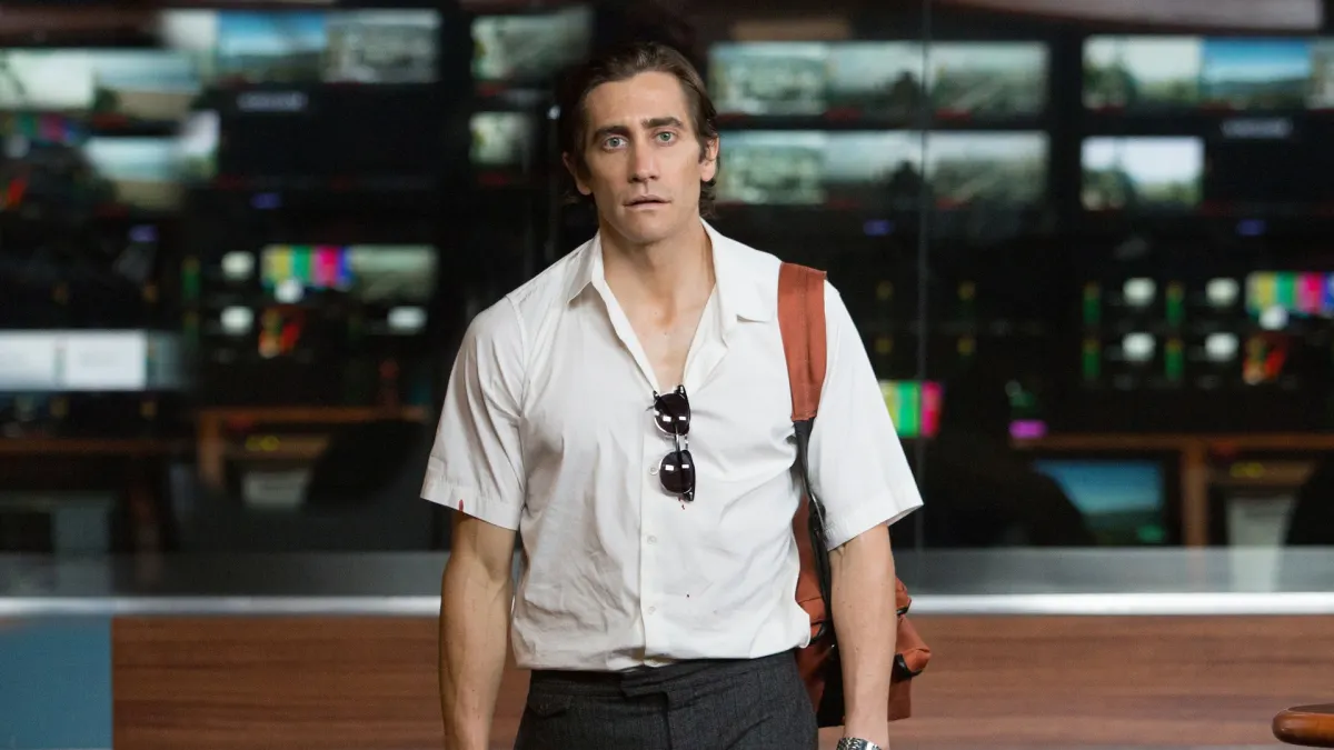Jake Gyllenhaal negotiating footage near crime scene tape in Nightcrawler